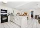 Modern kitchen with white cabinetry, black appliances, and a breakfast bar, seamlessly connected to the dining area for easy entertaining at 8801 Crayson Ct, Kissimmee, FL 34747
