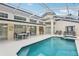 Backyard oasis featuring a sparkling pool and spa, covered lanai, and bar-style seating, perfect for outdoor entertaining and relaxation at 8801 Crayson Ct, Kissimmee, FL 34747