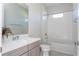 Bathroom featuring vanity with a white tiled tub and shower at 10427 Royal Cypress Way, Orlando, FL 32836