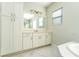 Bright bathroom features a large mirror, white cabinets, and a marble floor at 10427 Royal Cypress Way, Orlando, FL 32836