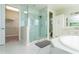 Bright primary bathroom featuring walk-in shower and marble floors at 10427 Royal Cypress Way, Orlando, FL 32836