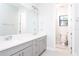 Bathroom with dual sinks, gray cabinets, and a separate toilet room at 10427 Royal Cypress Way, Orlando, FL 32836