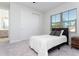 Bright bedroom with large window, gray carpet, and double closet at 10427 Royal Cypress Way, Orlando, FL 32836