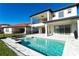Rear exterior view showcases the home with a pool, covered patio, and second-story balcony at 10427 Royal Cypress Way, Orlando, FL 32836