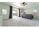 Spacious main bedroom featuring lake views, tray ceilings, a ceiling fan, and carpet flooring at 10427 Royal Cypress Way, Orlando, FL 32836