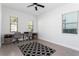 Bright home office with dual desks, ceiling fan, and natural light from large windows at 10427 Royal Cypress Way, Orlando, FL 32836