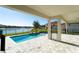 View from the covered patio features a pool, lake views, and meticulously landscaped backyard at 10427 Royal Cypress Way, Orlando, FL 32836