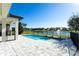 A beautiful backyard featuring a pristine pool with water features overlooking a serene lake view at 10427 Royal Cypress Way, Orlando, FL 32836