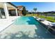The backyard has a stunning pool with a sun shelf, overlooking the tranquil lake and lush landscaping at 10427 Royal Cypress Way, Orlando, FL 32836