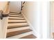 Elegant staircase features hardwood treads, white risers, and a curved handrail, leading to the upper level at 10427 Royal Cypress Way, Orlando, FL 32836