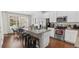 Modern kitchen featuring stainless steel appliances, a granite island, and an adjacent dining area, ideal for cooking at 11686 Water Run Aly, Windermere, FL 34786