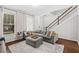 Inviting living room with a comfortable sectional sofa, soft rug, and staircase for access to the upper level at 11686 Water Run Aly, Windermere, FL 34786