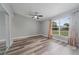 Bright bedroom with wood-look floors, ceiling fan, large window and closet at 1184 Calanda Ave, Orlando, FL 32807