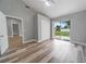 Bedroom featuring wood-look floors, closet, and sliding glass door with access to backyard at 1184 Calanda Ave, Orlando, FL 32807