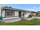 Single-story home boasts white exterior with gray trim, a secure front gate, and well-manicured landscaping at 1184 Calanda Ave, Orlando, FL 32807