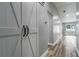 Bright hallway featuring light gray walls, luxury vinyl plank flooring, and modern farmhouse-style sliding barn door at 1184 Calanda Ave, Orlando, FL 32807
