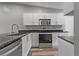 Modern kitchen featuring white cabinetry, stainless steel appliances, granite countertops, and a modern stainless steel sink at 1184 Calanda Ave, Orlando, FL 32807