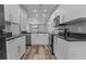 Bright and modern kitchen featuring white cabinetry, stainless steel appliances, and a view of the living space at 1184 Calanda Ave, Orlando, FL 32807
