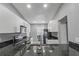 Modern kitchen featuring white cabinetry, granite countertops, stainless steel appliances, and a modern sink at 1184 Calanda Ave, Orlando, FL 32807