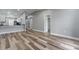Open-concept living room featuring luxury vinyl plank flooring, neutral gray walls and a view of the kitchen at 1184 Calanda Ave, Orlando, FL 32807