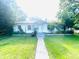 Charming single-story home with green lawn, trees and inviting pathway to the front door at 1403 N Fern Creek Ave, Orlando, FL 32803