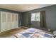 This bedroom features grey walls, a window with dark curtains, and bi-fold closet doors at 1421 Summit Hill Dr, Deltona, FL 32725