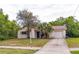 Charming single-story home featuring an attached garage and mature landscaping in the front yard at 1421 Summit Hill Dr, Deltona, FL 32725