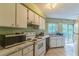 Efficient kitchen featuring white appliances, countertops, and cabinetry with backyard views at 1421 Summit Hill Dr, Deltona, FL 32725