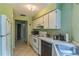 Efficient kitchen featuring white appliances, countertops, and cabinetry with access to the laundry and storage space at 1421 Summit Hill Dr, Deltona, FL 32725