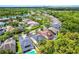 Aerial view of a home with a pool and backyard surrounded by lush green trees, situated in a suburban neighborhood at 14213 Southern Red Maple Dr, Orlando, FL 32828