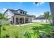 Expansive backyard featuring a covered patio, a well-manicured lawn, and lush landscaping at 14213 Southern Red Maple Dr, Orlando, FL 32828