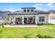 Spacious backyard featuring a covered patio with outdoor seating and a well-maintained lawn at 14213 Southern Red Maple Dr, Orlando, FL 32828