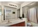 Bright bathroom with a large mirror, vanity, and a shower-tub combo behind a shower curtain at 14213 Southern Red Maple Dr, Orlando, FL 32828