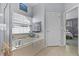 Bathroom featuring a soaking tub, large window, and access to the bedroom at 14213 Southern Red Maple Dr, Orlando, FL 32828