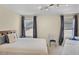 Comfortable bedroom featuring neutral walls, carpeted floors, a bed, and two windows with decorative curtains at 14213 Southern Red Maple Dr, Orlando, FL 32828
