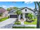 Charming home featuring a manicured lawn, beautiful landscaping, a two-car garage, and a welcoming front porch at 14213 Southern Red Maple Dr, Orlando, FL 32828