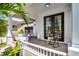 Charming front porch featuring rocking chairs, warm colors, decorative accents, and beautiful, shaded plants at 14213 Southern Red Maple Dr, Orlando, FL 32828