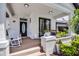 Inviting front porch featuring rocking chairs, neutral paint, a decorative door, and beautiful, shaded plants at 14213 Southern Red Maple Dr, Orlando, FL 32828