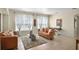 Bright living room with large windows, tile flooring, modern furniture, and a decorative area rug at 14213 Southern Red Maple Dr, Orlando, FL 32828