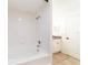 Clean bathroom showcasing a white tiled shower-tub combination, white fixtures, and tiled floor at 1530 Monica St, Deltona, FL 32725