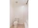 Well-lit bathroom with a classic white toilet, neutral tile flooring, and efficient ventilation at 1530 Monica St, Deltona, FL 32725