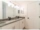 Bright bathroom featuring a double vanity with granite countertop, modern fixtures, and ample lighting at 1530 Monica St, Deltona, FL 32725