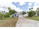Exterior shot of the home showcasing its modern design, long driveway, and manicured landscape at 1530 Monica St, Deltona, FL 32725