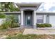 Front entrance to home featuring a blue door, white pillars, and manicured landscaping at 1530 Monica St, Deltona, FL 32725