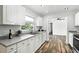Updated kitchen boasts white cabinets, stainless steel sink, and wood-look flooring at 161 Peacock, Altamonte Springs, FL 32701