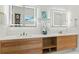 Bright bathroom features double vanity with stylish light fixtures, mirrors, and wood grain cabinets at 1620 S Eola Dr, Orlando, FL 32806