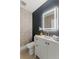 Modern powder room with textured accent wall, lighted mirror, and white vanity at 1620 S Eola Dr, Orlando, FL 32806