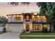 Captivating two-story house illuminated at dusk, features a brick driveway and a neatly maintained front lawn at 1620 S Eola Dr, Orlando, FL 32806