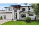 Beautiful two-story home with a modern exterior, green lawn, brick driveway, and attached garage at 1620 S Eola Dr, Orlando, FL 32806