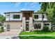Stately two-story home features a modern design, complete with a green lawn, brick driveway, and attached garage at 1620 S Eola Dr, Orlando, FL 32806